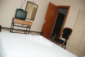 伊里斯斯Villa Maria的一间卧室配有一张床、一台电视和一面镜子