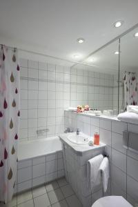 阿波尔达魏玛伯格酒店的带浴缸、水槽和镜子的浴室
