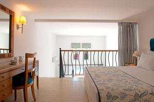 卡尔扎迈纳Mitsis Norida的酒店客房配有一张床、一张书桌和一张书桌。