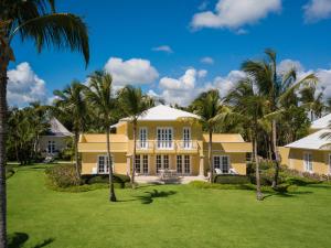 蓬塔卡纳托尔图加湾酒店的棕榈树黄色房屋的外部景色
