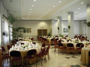 锡拉库扎Hotel Park Siracusa Sicily的宴会厅配有桌椅