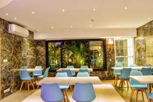 塔那那利佛Samsara Hotel的餐厅设有桌椅和大窗户。