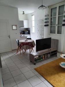 艾克斯莱班appartement cosy au calme et en centre ville的客厅配有桌子和电视