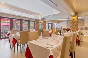 金边诺罗敦大道阿尼克精品水疗酒店的餐厅设有白色的桌椅和窗户。