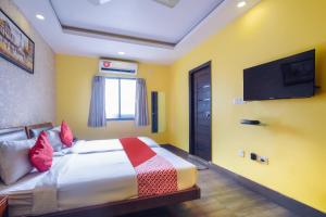 加尔各答Kiaan Inn的一间卧室配有一张床和一台平面电视