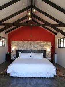WilhelmstalKhan River Lodge的卧室配有一张白色大床和红色墙壁