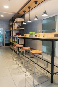 蒙得维的亚南共大学公寓式酒店的厨房设有带凳子和柜台的酒吧