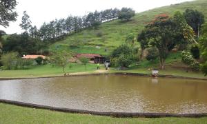 库尼亚Sitio Cantinho Verde Cedro的山丘下田野的池塘