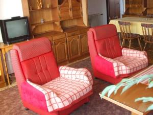 斯塔拉·里斯拉Rekreacny dom Altwaldorf Vysoke Tatry的客厅设有两张红色椅子和一台电视机