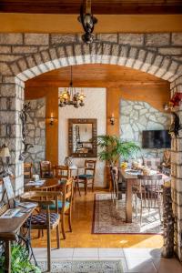 卡尔派尼西翁Semeli Guesthouse的一间带桌椅和石墙的用餐室