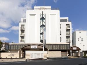 丰中Hotel Grand Fine Toyonaka Minami的前面有标志的白色建筑