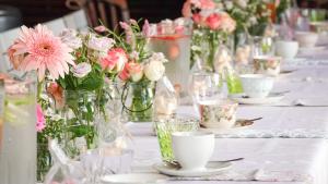 比勒陀利亚Spacube Luxury Suites and Spa的一张桌子,上面有花瓶,上面布满了粉红色的花