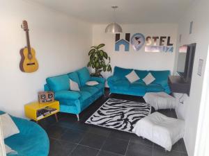 坎皮纳斯Hostel de Luz - Unidade 1的客厅配有蓝色沙发和吉他