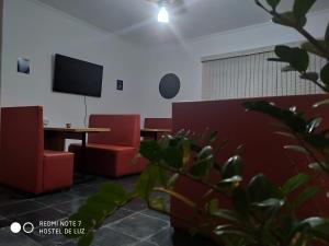坎皮纳斯Hostel de Luz - Unidade 1的配有桌子和两把椅子以及电视的房间