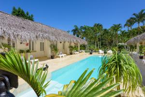 拉斯特拉纳斯Adults-Only Hacienda Terra Taina的一个带游泳池和棕榈树的度假村