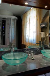 绍萨尔地区基策克das kappel wein gut hotel的浴室里设有两个水槽,在柜台上放着绿色的碗