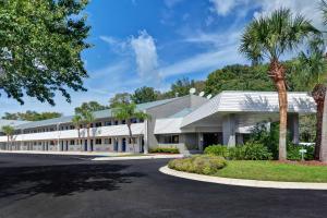 杰克逊维尔Studio 6-Jacksonville, FL - Baymeadows的一座白色的大建筑,前面有棕榈树