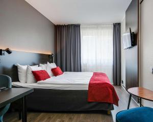 卡尔斯塔德Best Western Hotel Savoy的酒店客房配有一张带红色枕头的大床