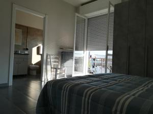 格拉索比奥LE MURA Foresteria的一间卧室配有一张床,厨房设有阳台