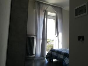 格拉索比奥LE MURA Foresteria的一间卧室配有一张床,玻璃门设有窗户