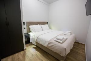 雅典Raise Acropolis View Suites的卧室配有白色的床和2条毛巾