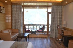 马拉里The Holiday Villa Resorts & Spa的酒店客房设有一张床和一个阳台。