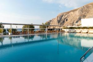 卡马利卡马里海滩酒店的一个带桌椅的大型蓝色海水游泳池