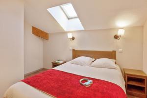 瓦尔Résidence Pierre & Vacances l'Albane的一间卧室配有一张带红色毯子的大床