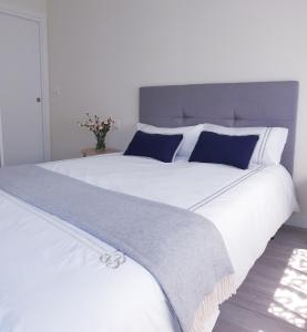 伊伦NICORÉS的一张白色的大床,配有蓝色和白色的枕头