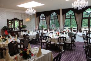 宾格利奥克伍德大厅酒店的用餐室配有桌椅和吊灯。