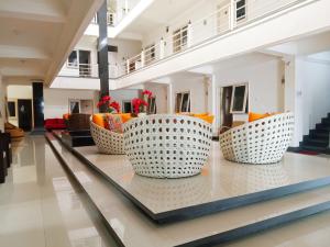 马塔兰Gading Guest House的大堂配有橙色和白色的椅子