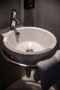 塞萨洛尼基Domotel Olympia的浴室内的一个白色水槽,配有毛巾