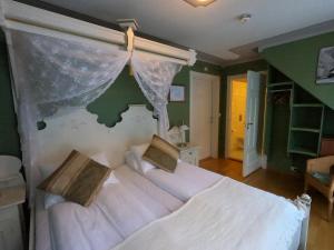 耶勒埃兰酒店的一间卧室配有一张带天蓬的大型白色床