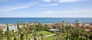 安塔利亚塞拉俱乐部酒店的拥有游泳池、棕榈树和海洋的度假胜地