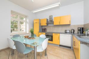 莱比锡Große Freiheit的厨房配有黄色橱柜和桌椅