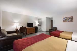 埃斯卡诺巴Econo Lodge Inn & Suites的酒店客房设有两张床和电视。