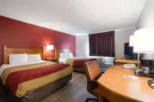 埃斯卡诺巴Econo Lodge Inn & Suites的酒店客房配有两张床和一张书桌