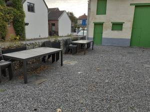 BassengeLes gîtes du Broukay - Alouette的砾石庭院设有两张野餐桌和椅子