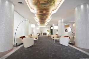 贝加莫圣马可高级酒店的大堂设有白色椅子和天花板上的绘画作品