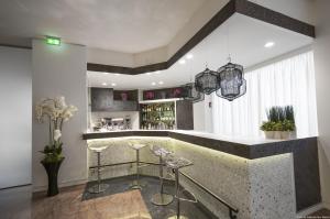 贝加莫圣马可高级酒店的厨房设有酒吧,里面摆放着凳子