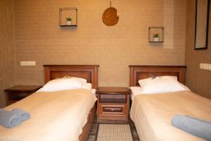 基辅波格丹诺夫亚尔酒店的一间客房配有两张床和两张带毛巾的桌子。