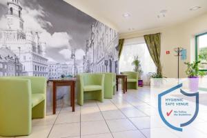 波兹南泽罗尼酒店的一间设有绿色椅子和壁画的等候室