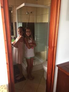 萨尔瓦尔Cherry Apartmanház的两个女孩站在带淋浴的浴室