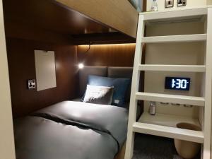 迪拜sleep 'n fly Sleep Lounge, C-Gates Terminal 3 - TRANSIT ONLY的一间卧室设有两张双层床和闹钟