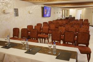 新帕扎尔Hotel Vrbak ND的一间会议室,配有桌椅和屏幕