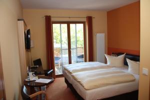 新勃兰登堡Badehaus Hotel & Restaurant的酒店客房设有一张床和一个阳台。