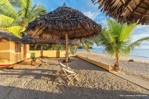 Ambaro萨姆巴特拉住宿加早餐旅馆的海滩上的一把草伞和椅子