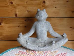 LabuissièreAu Crapaud Charmant的青蛙的雕像,坐在冥想的姿势中,拿着杯子