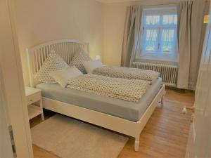 若特阿赫-埃根Ferienwohnung Giacomelli 4的卧室配有带枕头的床铺和窗户。
