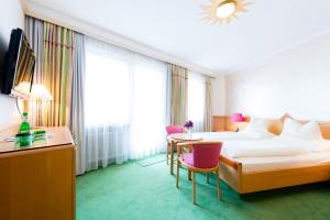 兰德埃克斯科洛芬斯坦酒店的酒店客房带一张床、一张桌子和椅子